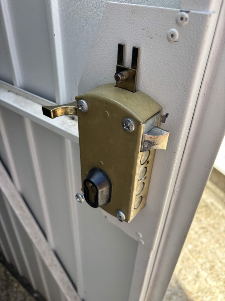 Locksmith fitting a new garage door lock at a Hythe Marina property