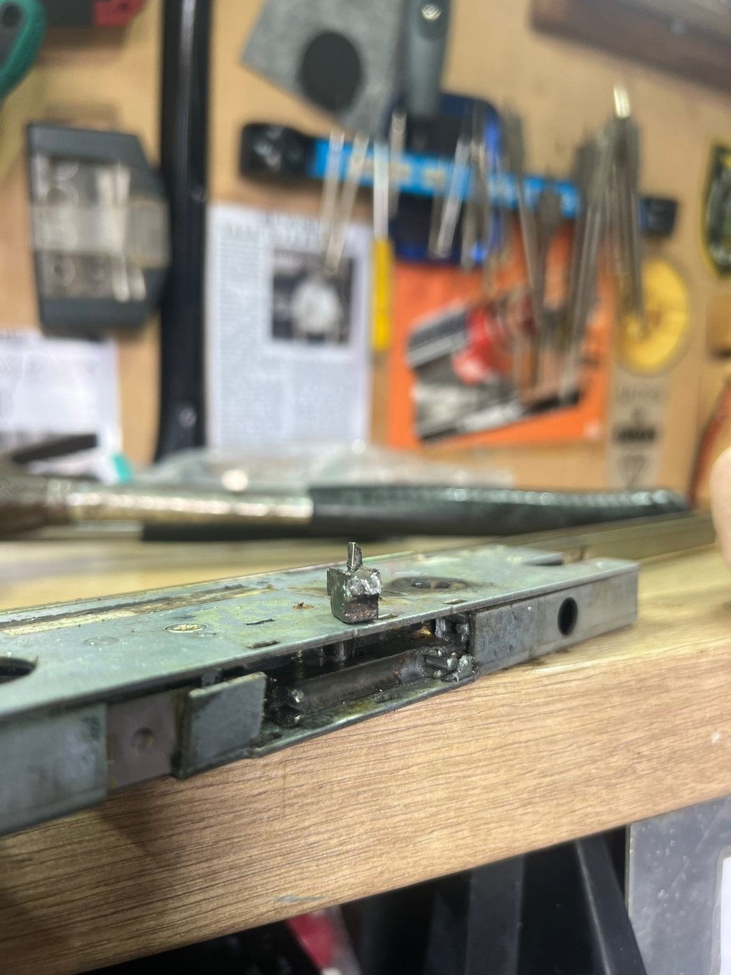 The failed Winkhaus gearbox on the van bench, casing corroded and the cam sheared off