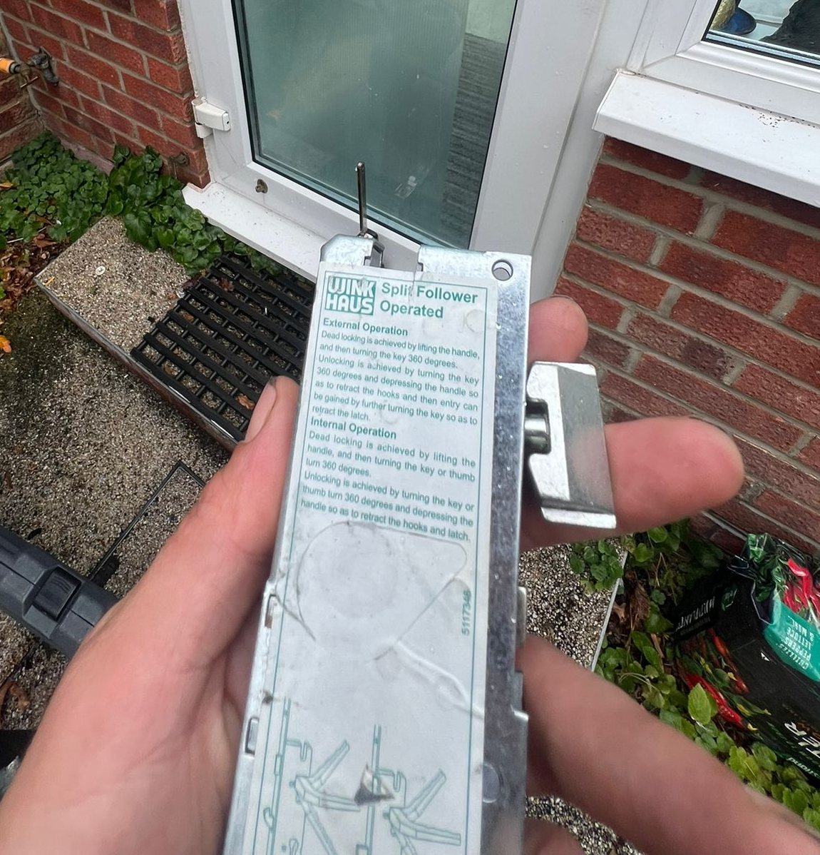 The replacement Winkhaus split follower gearbox, held up in front of the door