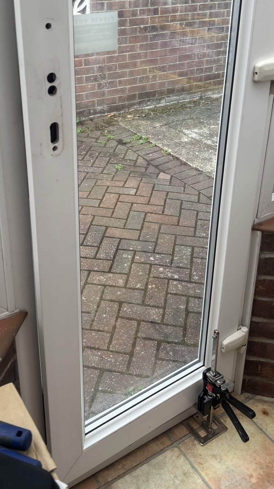 uPVC side door with the lock mechanism taken out and the door lifted on a jack to realign it