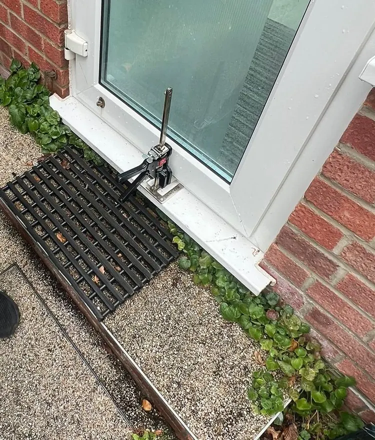 A Viking Arm lifting jack at the threshold, holding the door at height while the hinges are set